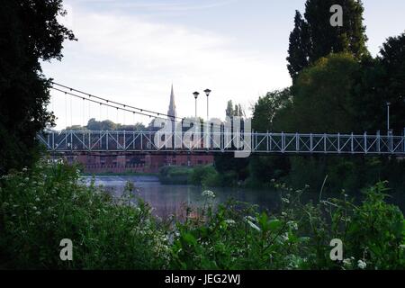 Karottenhosenträger Wehr Hängebrücke über den Fluss Exe und der Turm der Kirche St. Leonard im Morgengrauen. Exeter, Devon, UK. Juni 2017. Stockfoto