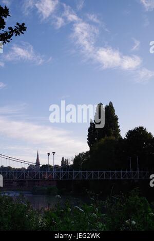 Karottenhosenträger Wehr Hängebrücke über den Fluss Exe und der Turm der Kirche St. Leonard im Morgengrauen. Exeter, Devon, UK. Juni 2017. Stockfoto