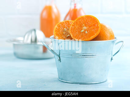 Mandarinen in Metallschale und auf einem Tisch Stockfoto