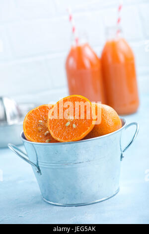 Mandarinen in Metallschale und auf einem Tisch Stockfoto