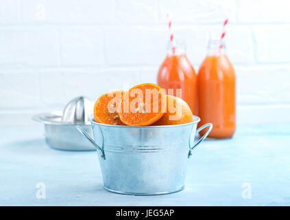 Mandarinen in Metallschale und auf einem Tisch Stockfoto