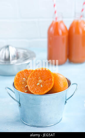 Mandarinen in Metallschale und auf einem Tisch Stockfoto