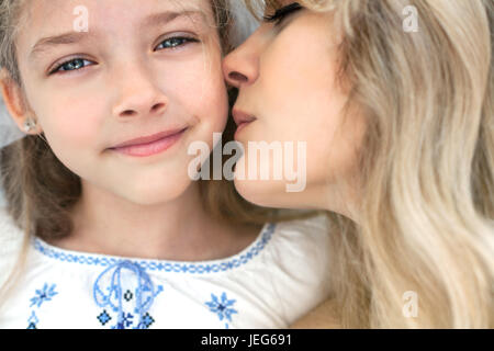 Mutter küsst ihre kleine Tochter. Close-up Portrait. Stockfoto