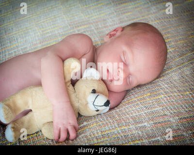 Kleines Baby schläft mit einer Toy Teddybär Stockfoto