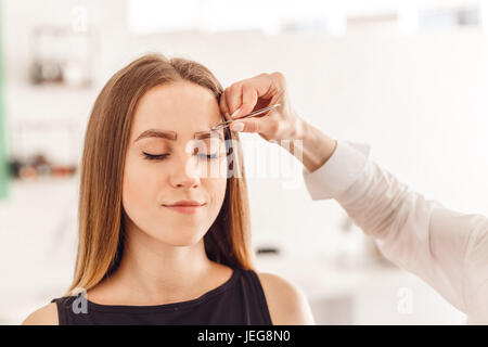 Meister Make-up korrigiert und gibt die Form mit der Pinzette herausziehen Stockfoto