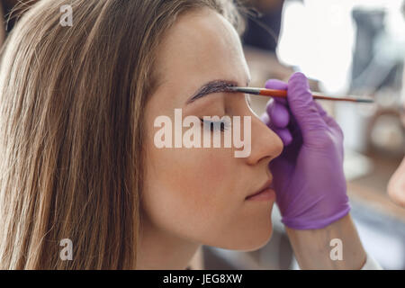 Malerei-Client Augenbrauen im Salon zu meistern. Stockfoto