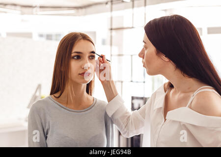 Meister Make-up korrigiert und gibt die Form für Augenbrauen in einem Schönheitssalon. Stockfoto