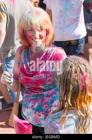 Fröhliche schöne Frau auf dem Festival der Farben Stockfoto