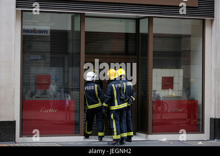 London, UK. 25. Juni 2017. Feuerwehr und Polizei reagiert auf Alarmton außerhalb Ernest Jones Schmuck Magazin auf Cheapside in der Nähe von Bank-Station in der Londoner City. Feuerwehrfahrzeuge vor den Geschäften und Polizei Verkehr auf Cheapside Aussetzung geparkt. In der Nähe von Menschen beobachten Polizei und Feuerwehr außen Ernest Jones Shop zu sammeln. Lauter Alarm ertönt Umgebung. Feuerwehrfahrzeuge waren die ersten, zu reagieren, wie Polizei wenige Minuten später eintraf. Alles sieht sicher von außen keine sichtbaren Feuer zu sehen oder kein Rauch, überall in der Gegend zu sehen. Bildnachweis: Antanas Martinkus für CTJA/Alamy Live-Nachrichten Stockfoto