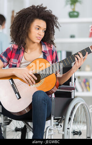 behinderte Frau, die Gitarre zu spielen Stockfoto