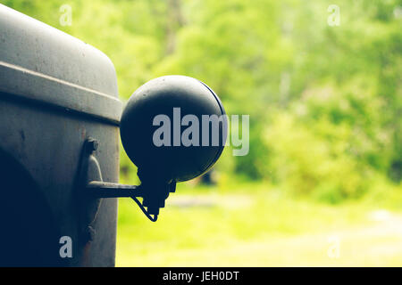 Scheinwerfer von einem alten Traktor in einer alten Scheune mit grünem Hintergrund Stockfoto