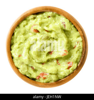 Guacamole in Holzschale. Auch kurze Guac, eine leichte grüne Dip oder Salat, gemacht von zerdrückte Avocados, Tomaten, Zwiebeln, Knoblauch, Zitrone, Cayennepfeffer, Salz. Stockfoto