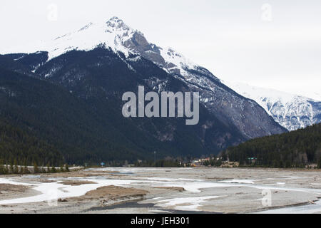 Die schneebedeckten Gipfel der kanadischen Rockies erheben sich über den Trans-Canada Highway im Westen Kanadas. Die Straße schneidet quer durch Kanada auf einer Ost-West-Achse. Stockfoto