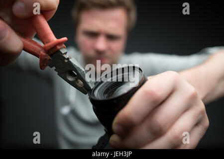 Gut aussehend Fotograf mit Kamera im Fotostudio Stockfoto