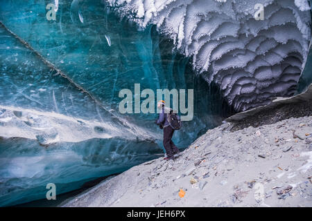 Ein Mann erforscht einen Tunnel unter dem Eis des Canwell-Gletscher in Alaska Range im Winter; Alaska, Vereinigte Staaten von Amerika Stockfoto