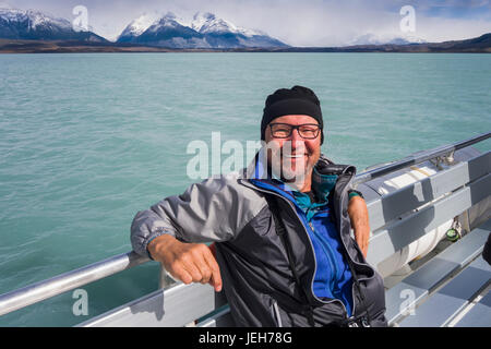 Ein Tourist sitzt auf einem Boot und posiert für ein Foto auf einer Kreuzfahrt des Lago Argentino in der Nähe von El Calafate, Argentinien Patagonien Stockfoto