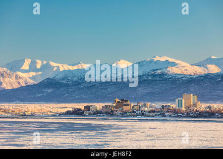 Blick Auf Die Innenstadt Von Anchorage Im Winter Und Die Schneebedeckten Chugach Mountains Dahinter Vom Point Mackenzie Aus Gesehen, Die Skies Im Hintergrund Klar Und ... Stockfoto