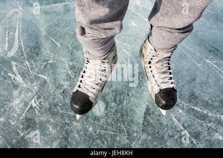 Erhöhte Ansicht und Nahaufnahme von Schlittschuhen auf dem Eis; Calgary, Alberta, Kanada Stockfoto