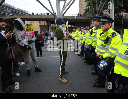 Aktivisten antreten mit der Polizei, wie sie über den Tod von Edir Frederico Da Costa, protestieren, die starb am 21. Juni sechs Tage, nachdem er in einem Auto von Schnepfen, Beckton, in Newham, Ost-London Metropolitan Police Offizieren gestoppt wurde. Stockfoto