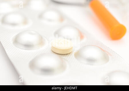 Empfängnisverhütende Tabletten in Paketen und ohne auf hellem Hintergrund.