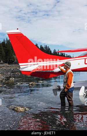 Mann stand neben einem Wasserflugzeug Cessna 206 im Hobo Bay, Port Wells, Prinz-William-Sund, Yunan Alaska, USA Stockfoto