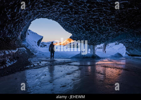 Ein Mann geht, der Eingang eines Ice-Tunnels an der Endstation des Canwell-Gletscher in Alaska Range mitten im Winter; Alaska, Vereinigte Staaten von Amerika Stockfoto