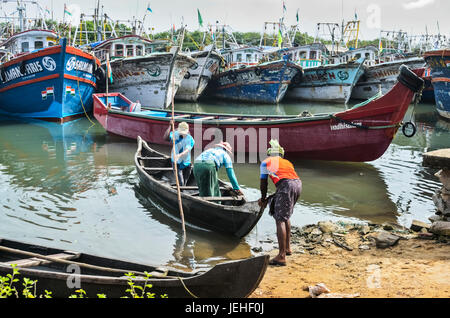 Fischer Druck kleine Boot heraus und bunte Fischerboote; Kadappuram, Kerala, Indien Stockfoto