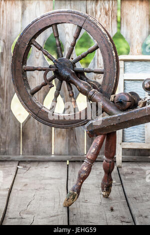 Alte Nähmaschine Spindel steht auf der Terrasse des alten Holzhaus. Stockfoto