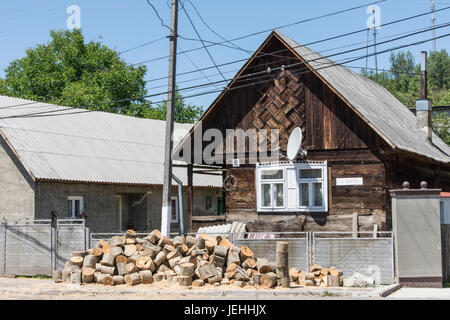 Ein typisches Holzhaus mit einigen Brennholz-Stapel im Freien in der Ukraine Stockfoto