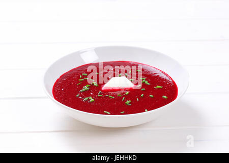 Teller mit rote Bete Creme Suppe auf weißem Holz Hintergrund Stockfoto
