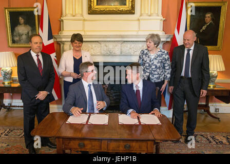 Premierminister Theresa May steht mit ersten Staatssekretär Damian Green (rechts), DUP Leader Arlene Foster (zweiter von links), DUP Deputy Leader Nigel Dodds (links), als DUP Wartungstafel Sir Jeffrey Donaldson (dritte rechts) befasst sich mit parlamentarischer Staatssekretär an den Fiskus abgeführt und Chief Whip, Gavin Williamson, inside10 Downing Street, London, nach der DUP vereinbart einen deal, die Minderheit konservative Regierung zu unterstützen. Stockfoto