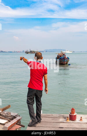 GEORGE TOWN, MALAYSIA - 27 März: Malaysischer Mann zeigt etwas im Wasser am 27. März 2016 in George Town, Malaysia. Stockfoto