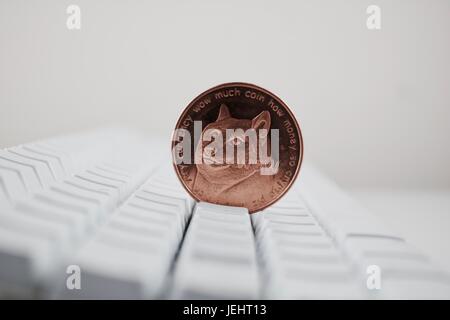 Kryptowährung physische Messing Dogecoin Münze auf der weißen Computertastatur. Stockfoto