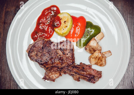 Steak mit gegrilltem Gemüse, serviert auf einem weißen Teller. Stockfoto