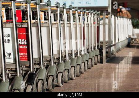 PEKING – 9. DEZEMBER 2011. Gepäckwagen am Flughafen Beijing Capital aufgereiht. Es hat registrierten 488.495 Flugzeug Bewegungen (Starts und Landungen), r Stockfoto