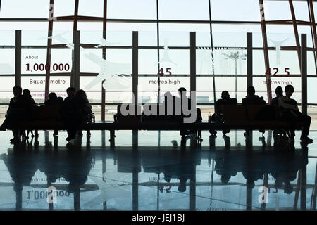 PEKING – DEZ. 16, 2011. Reisende vor einem großen Fenster Abflughalle, Beijing Capital International Airport, Terminal 3. Stockfoto