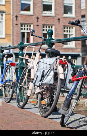Rosa Fahrrad geparkt gegen ein Geländer im historischen Grachtengürtel, Amsterdam, Niederlande Stockfoto