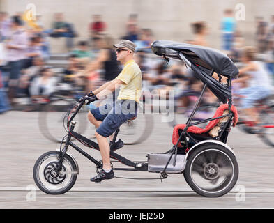 AMSTERDAM, 19. AUGUST 2012. Fahrer auf seinem Fahrrad Taxi am Dam Platz. Amsterdam Bike Taxi bietet einzigartige Rikscha-Touren durch das Stadtzentrum. Stockfoto