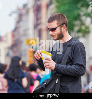 AMSTERDAM, 19. AUGUST 2012. Cool Kerl essen Pommes mit Mayonnaise. Holländer bekommen nicht genug von Pommes Frites. Sie essen über 41 Millionen Kilo jährlich. Stockfoto