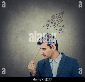 Erfolgreicher Geschäftsmann denken und schaffen mit einem Bleistift wies auf seinen Kopf eine Coloruful Gehirn aus Gang über den Kopf, Ziele zu setzen, auf der Suche nach f Stockfoto