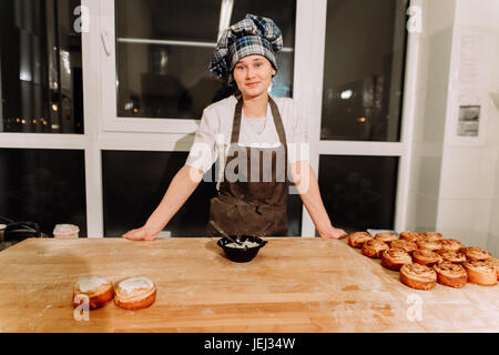 Frau backen Kuchen. Konditoren machen Desserts. Brötchen zu machen. Teig auf dem Tisch Stockfoto