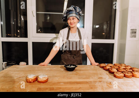 Frau backen Kuchen. Konditoren machen Desserts. Brötchen zu machen. Teig auf dem Tisch Stockfoto