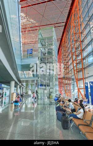PEKING, 15. JULI 2016. Interieur mit Passagiersitzen und Aufzug, Beijing Capital International Airport, Terminal 3. Stockfoto