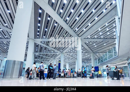 PEKING – SEPTEMBER. 5, 2012. Große Gruppe von Reisenden an der Gepäckausgabe Beijing Capital Airport Terminal 3. Stockfoto