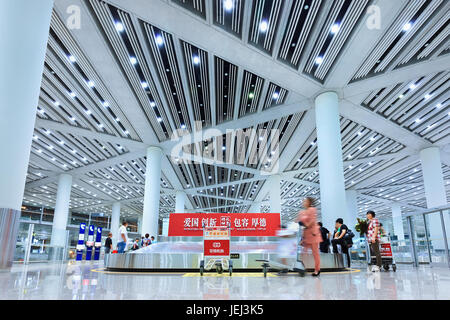 PEKING – SEPTEMBER. 5, 2012. Große Gruppe von Reisenden an der Gepäckausgabe Beijing Capital Airport Terminal 3. Stockfoto