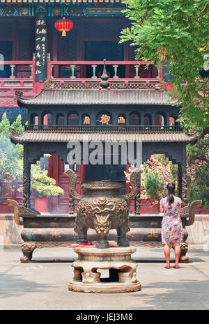 PEKING, 16. JUNI 2015. Frau vor dem Altar am Tempel der Weißen Wolke (Bai Yun Guan), taoistischer Tempel und Kloster im Stadtzentrum von Peking. Stockfoto