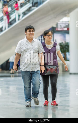 PEKING-15. MAI 2016. Übergewichtige Paare in einem Einkaufszentrum. Die durchschnittliche Taille der chinesischen städtischen Männchen hat von 63.5 cm in 1985 auf 76.2 cm gegangen. Stockfoto