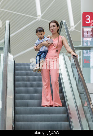 PEKING, 4. AUGUST 2106. Junge Frau mit Kind im Einkaufszentrum. China ist besorgt über die alternde Bevölkerung und hat seine Politik der Kindereinbindung beendet. Stockfoto