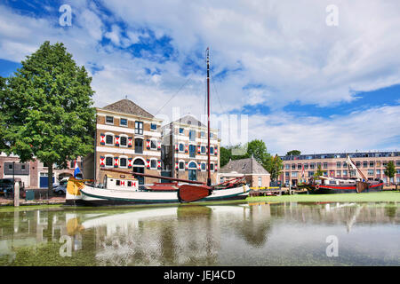 Alte renovierte Villa mit einem weißen vertäut Boot spiegelt sich in einem Kanal. Stockfoto