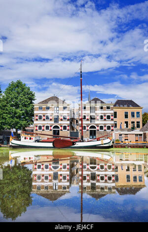 Renoviertes monumentales Herrenhaus mit einem weißen festgemachten Boot spiegelt sich in einem Kanal. Stockfoto